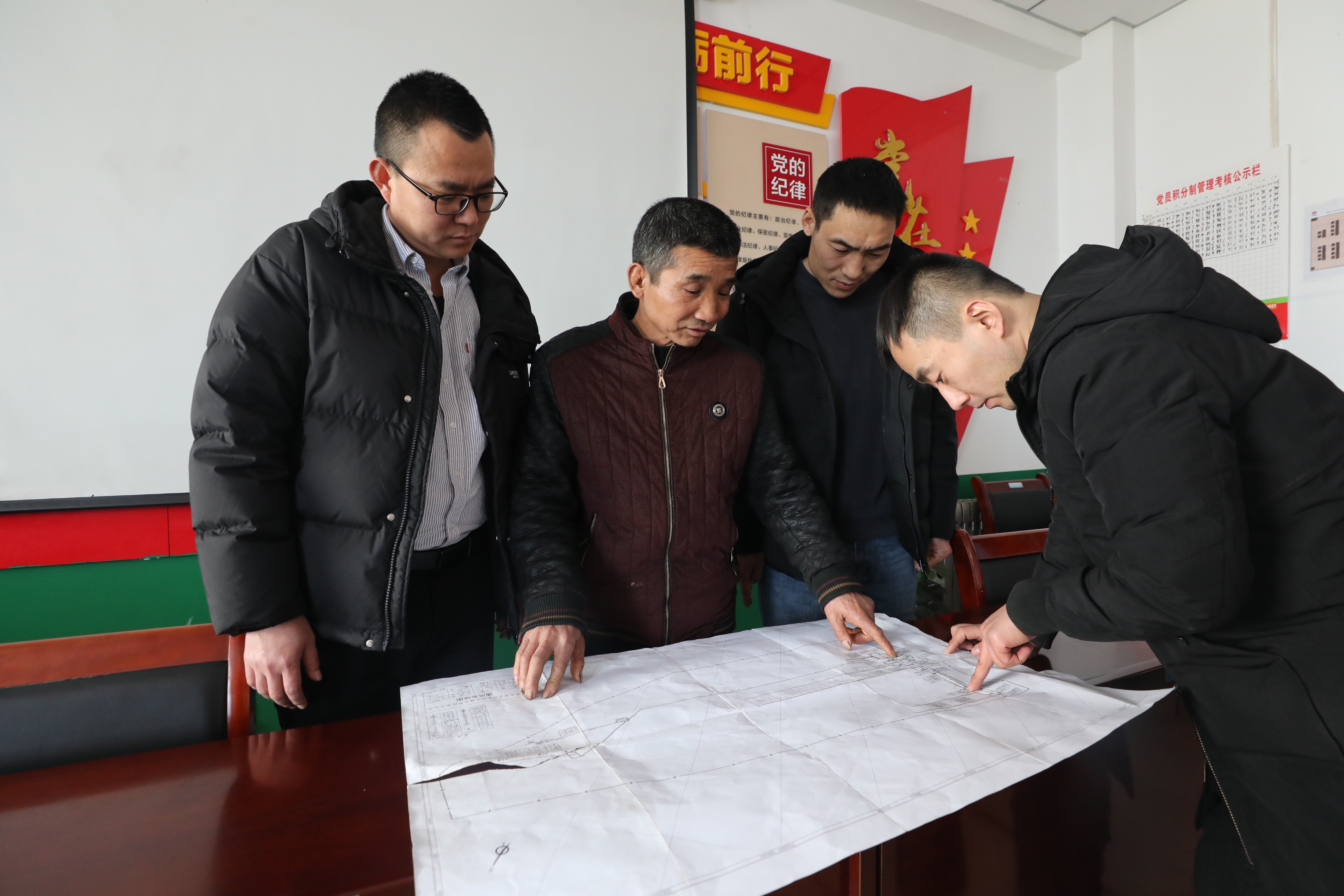 圖為張培均（左2）正在和隊部技術人員探討過斷層支護技術措施.JPG