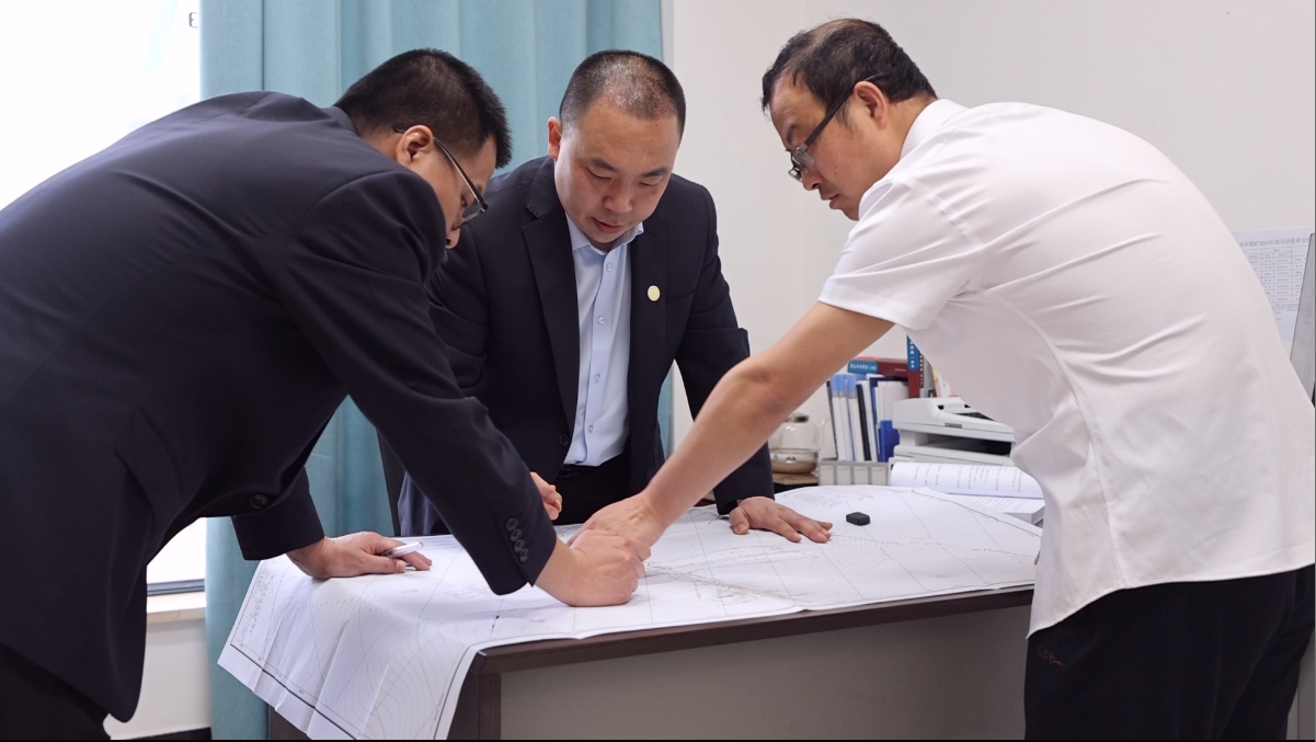 圖為澄合礦業(yè)西卓煤礦技術攻關小組正在對礦井通風系統(tǒng)進行討論研究.jpg